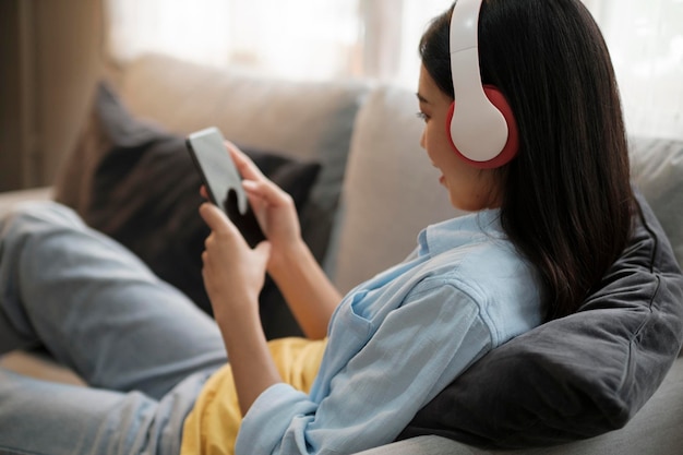Jovem ouvindo música usando smartphone em casa