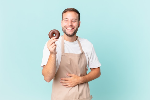 Jovem padeiro bonito com um donut