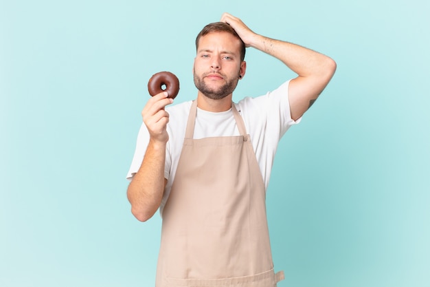 Jovem padeiro bonito com um donut