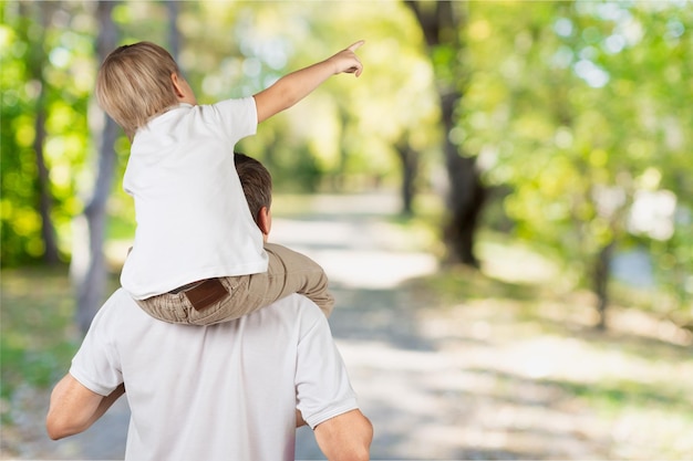 Jovem pai com filho no fundo do parque