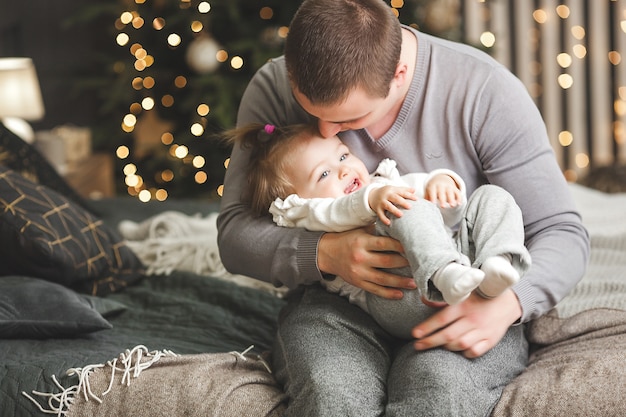 Jovem pai com sua filhinha no fundo do Natal