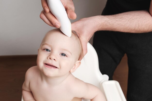 Jovem pai corta o primeiro cabelo de seu filho