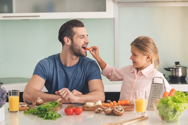 Jovem pai e filha cozinhando juntos