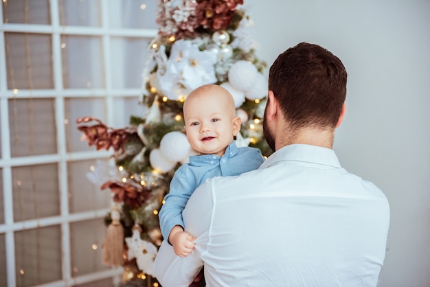 Jovem pai feliz com seu doce bebê no Natal