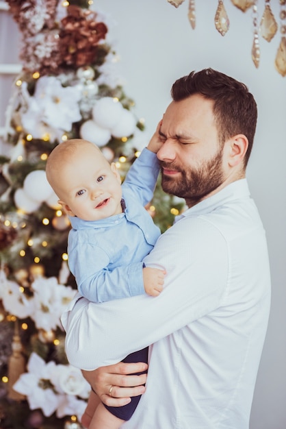 Jovem pai feliz com seu doce bebê no Natal