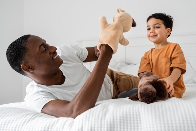 Foto jovem pai pagando com brinquedos com seu filho