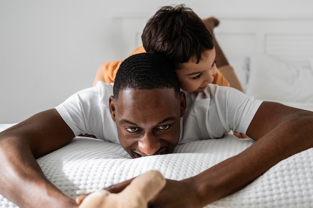 Foto jovem pai pagando com seu filho no quarto