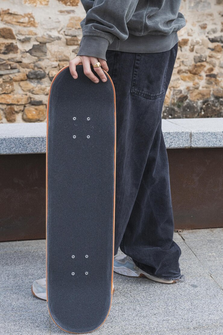 Foto jovem patinador segurando sua prancha ao ar livre