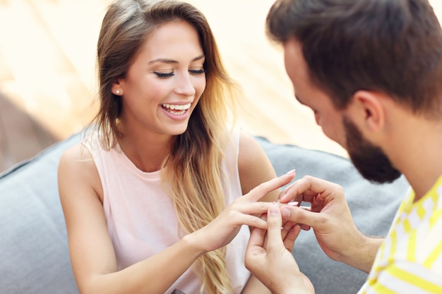 Jovem pedindo mulher bonita em casamento ao ar livre