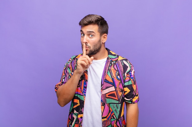 Jovem pedindo silêncio e sossego, gesticulando com o dedo na frente da boca, dizendo shh ou guardando um segredo