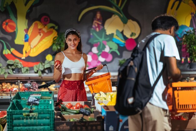 Foto jovem pegando a escolha de tomate na mercearia