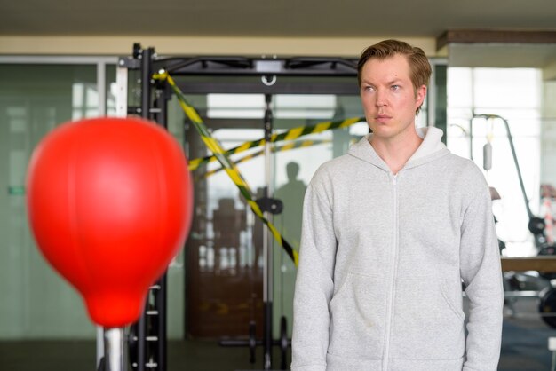 Jovem pensando e pronto para o boxe na academia