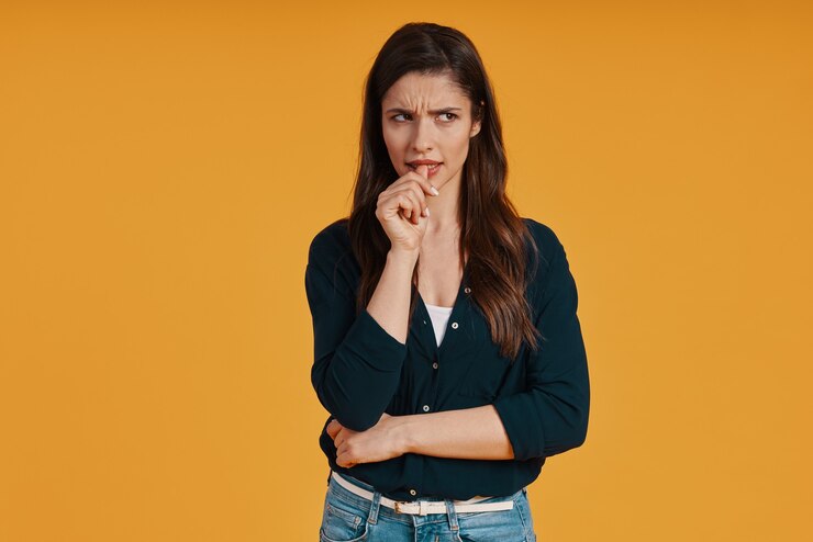Foto jovem pensativa em casual olhando para longe em pé contra um fundo amarelo