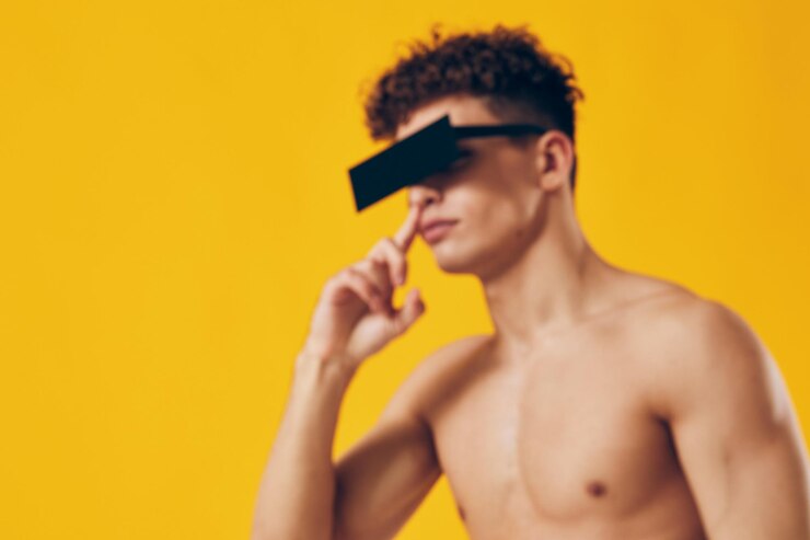 Foto jovem pensativo com óculos de sol elegantes posando com confiança contra um fundo amarelo vibrante conceito de moda e auto-expressão