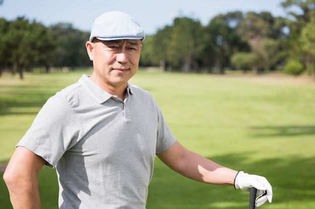 Jovem pensativo com taco de golfe