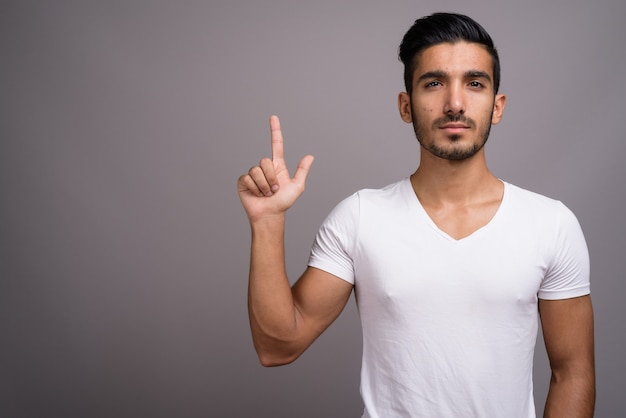 Jovem persa bonito contra um fundo cinza