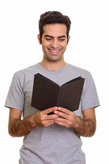 Jovem persa feliz lendo livro isolado
