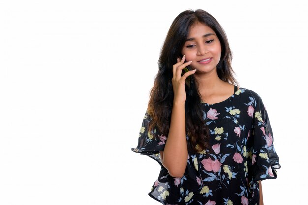 Jovem persa feliz sorrindo enquanto fala ao telefone