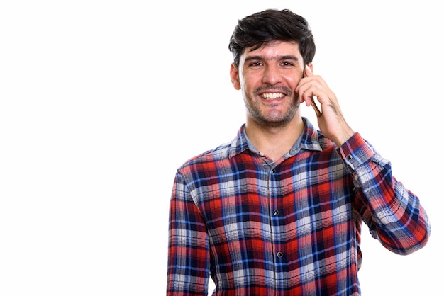 Jovem persa feliz sorrindo enquanto fala ao telefone