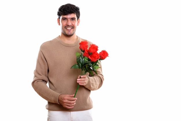 jovem persa feliz sorrindo enquanto segura rosas vermelhas