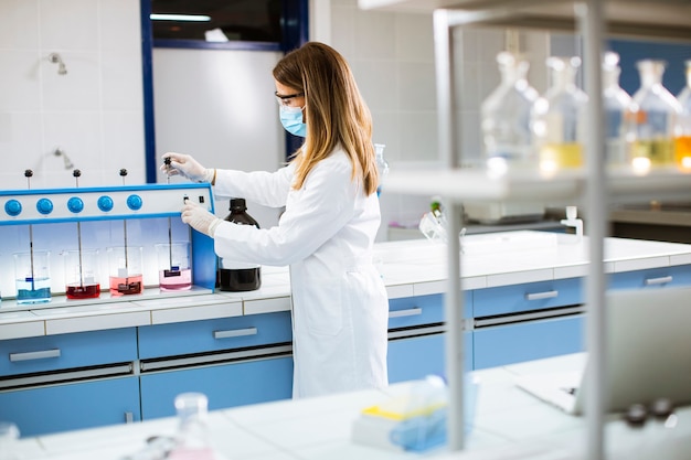 Jovem pesquisadora analisando dados químicos no floculador em laboratório