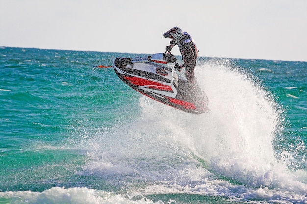 Jovem piloto profissional de jet ski realiza muitos truques nas ondas