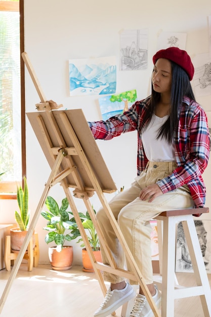 Jovem pintando em papel em casa moldura de madeirahobby e estudo de arte em casa