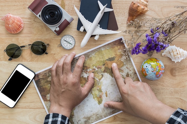 Jovem planejando viagens de férias com mapa. vista do topo.