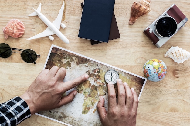 Foto jovem planejando viagens de férias com mapa. vista do topo.