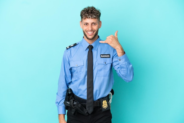 Jovem policial loiro isolado branco sobre fundo azul fazendo gesto de telefone Ligue-me de volta sinal