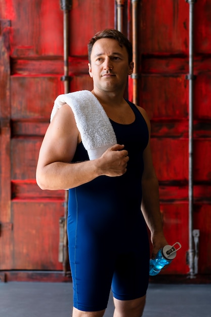 Jovem posando em roupas e equipamentos de luta livre