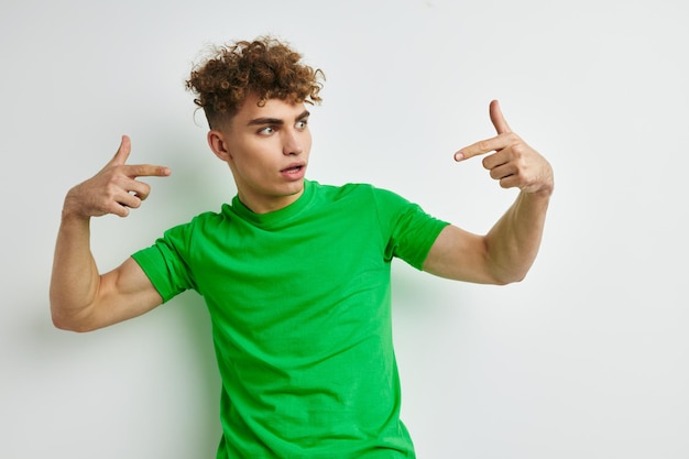 Jovem posando em um fundo branco com uma camiseta verde