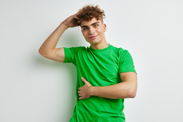 Jovem posando em um fundo branco com uma camiseta verde