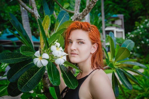 Jovem posando perto de flores