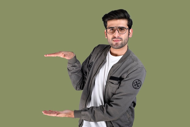 jovem pose frontal mostrando a oferta ou publicidade de um objeto modelo indiano do paquistanês