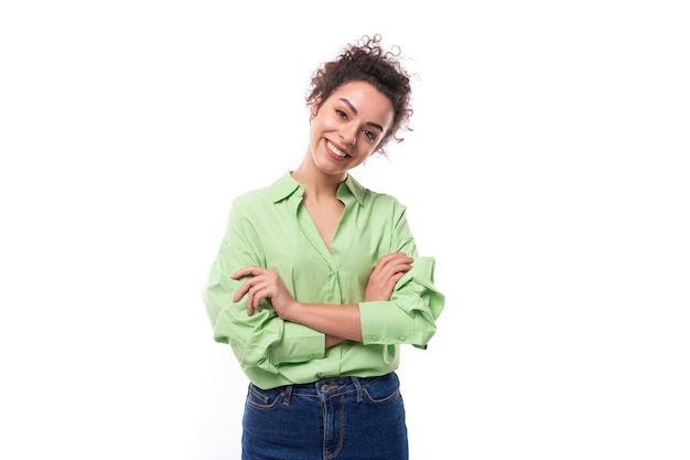 Foto jovem positiva alegre esbelta brunette europeia mulher encaracolada com um ponytail penteado está vestido