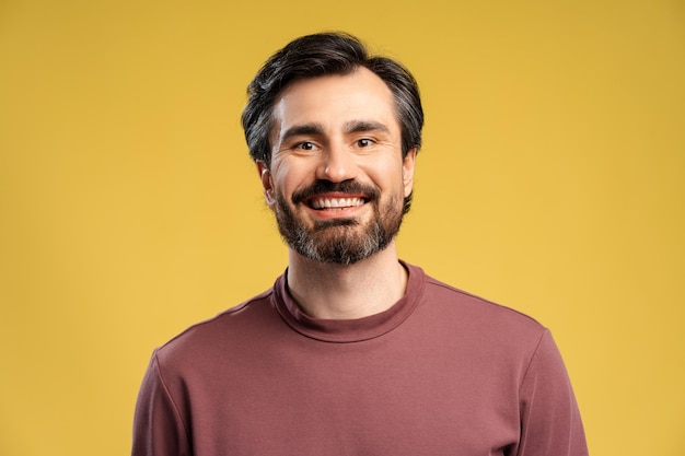 Jovem positivo vestindo casual posando isolado em amarelo olhando para a câmera
