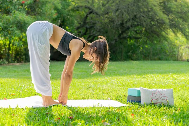 Jovem praticando ioga em um conceito verde ParkWellness