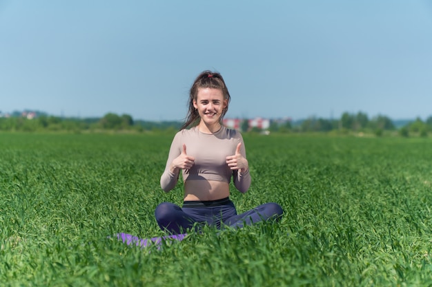 Jovem praticando ioga no campo