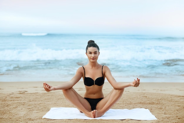 Jovem praticando meditação matinal na natureza na praia Linda garota fazendo ioga Lótus