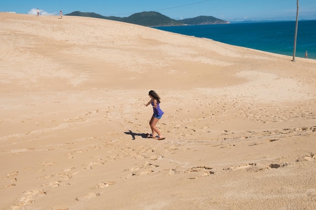 Jovem praticando sandbord nas dunas de Florianópolis, Brasil