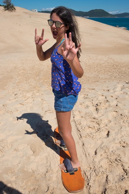 Jovem praticando sandbord nas dunas de Florianópolis, Brasil