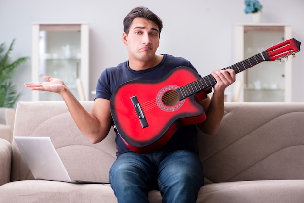 Jovem praticando tocando violão em casa