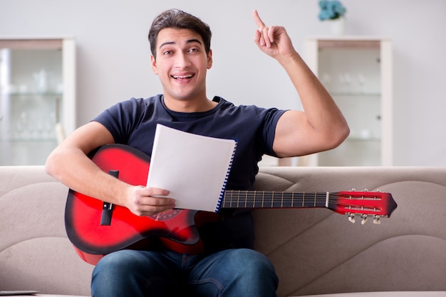 Jovem praticando tocando violão em casa