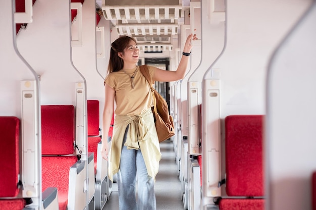 Foto jovem procurando um lugar para guardar sua bagagem nas viagens de turismo de férias de trem