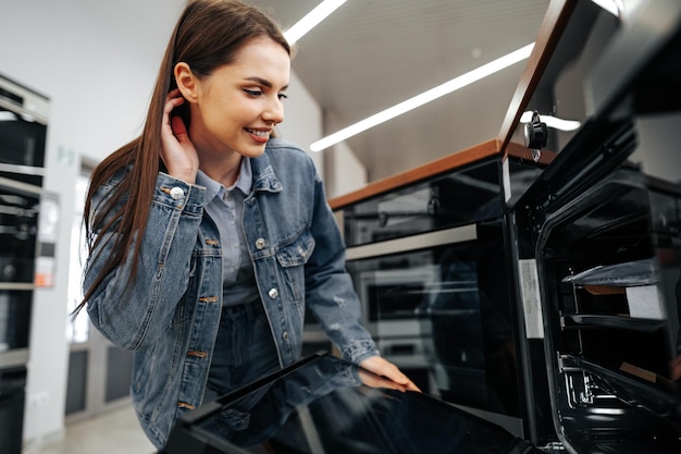 Jovem procurando um novo forno elétrico em um shopping