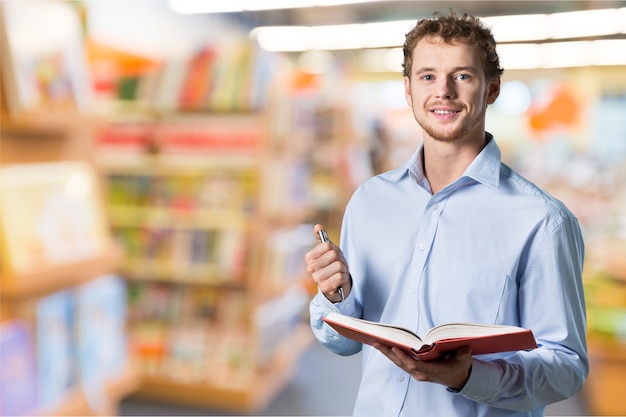 Jovem professor em pé com um livro