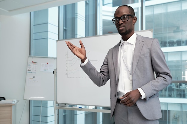 Jovem professor masculino confiante explicando informações financeiras do público