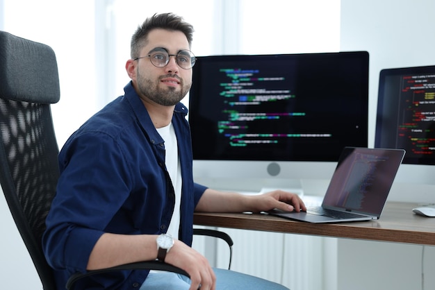 Jovem programador a trabalhar na secretária de um escritório