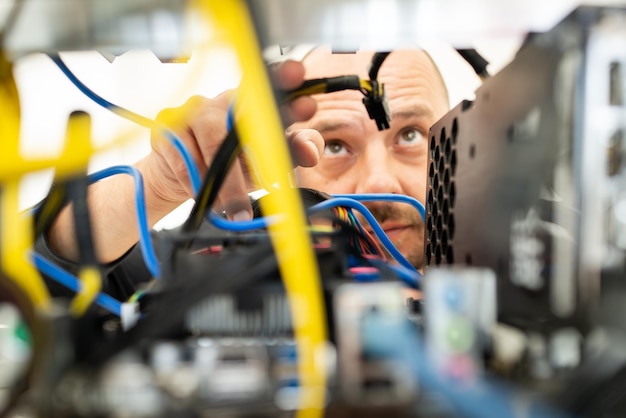 Jovem programador ajustando equipamento de mineração de criptomoeda para configurações operacionais ideais. foto de alta qualidade